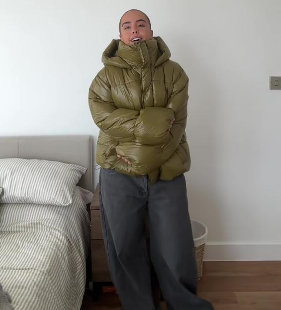 Woman wearing a green Primark puffer jacket.