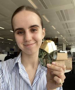 Woman holding a bottle of perfume.