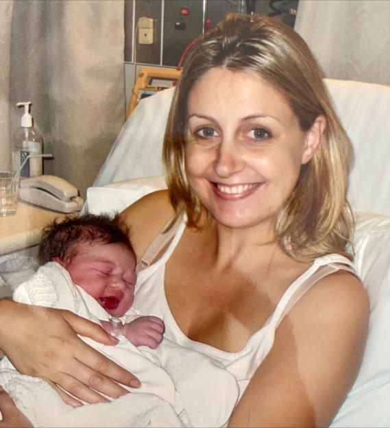 A woman holding a newborn baby in a hospital bed.