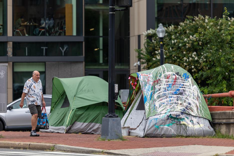 Man walking past homeless encampment in Washington, D.C.