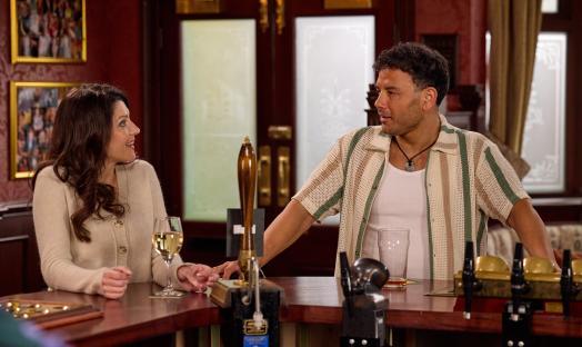 A man and woman talking at a pub.