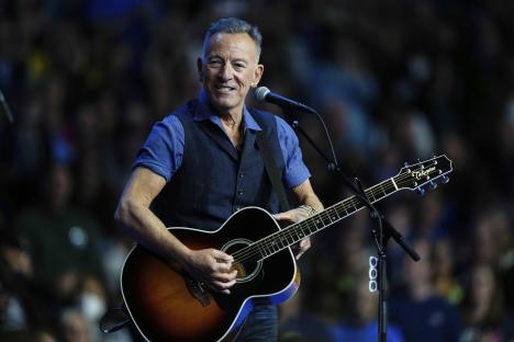 Bruce Springsteen performing with an acoustic guitar.