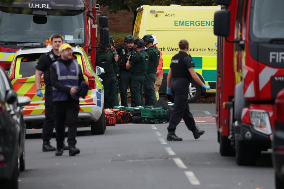 Emergency personnel, including paramedics, police, and firefighters, at an incident scene in Manchester, Britain.