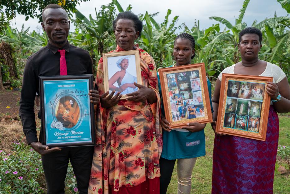 Family members holding framed photos of deceased loved one.