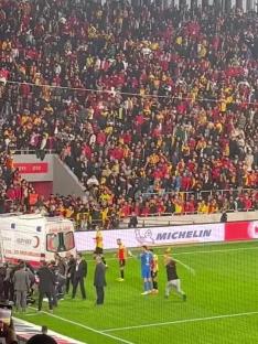 A fan runs onto a soccer field and hits a goalkeeper with a corner flag.