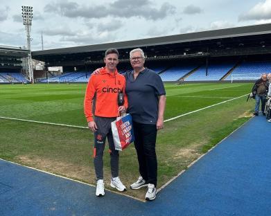 Dean Henderson with his father at a soccer stadium.
