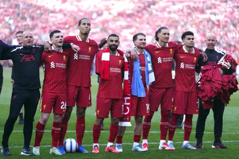 Liverpool players celebrating a Premier League victory at Anfield.