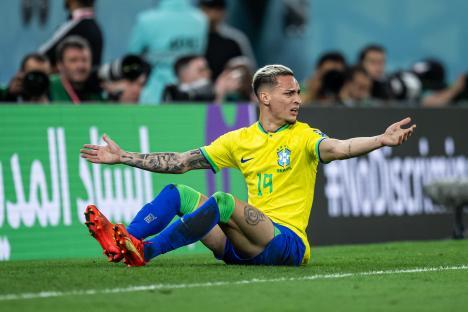 Antony of Brazil sitting dejected on the pitch.