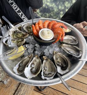 Oysters, shrimp, and sauce on ice.