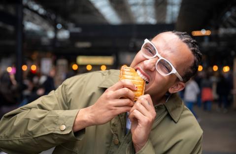 Person biting into a pastry.