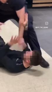 A security guard apprehending a shoplifter.