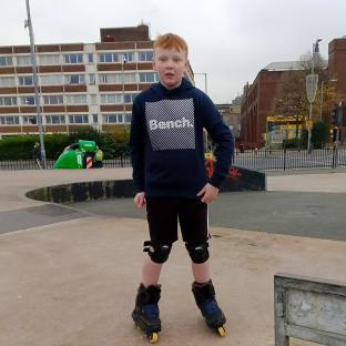 Boy wearing rollerblades in a skate park.