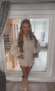 Woman in beige shirt dress and boots.
