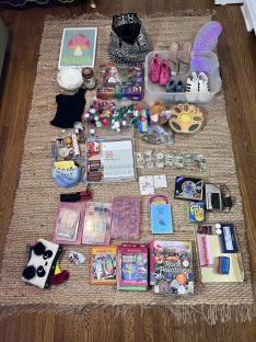 Collection of items found dumpster diving, including toys, clothes, shoes, and cash.
