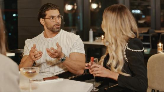A man and woman having a conversation at a restaurant.
