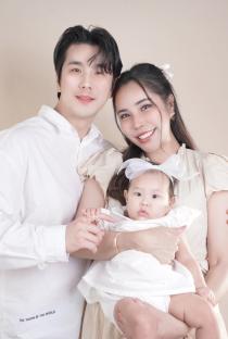 Family portrait of parents holding their baby.