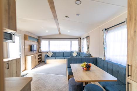 Interior of a holiday park home with light wood furniture and a blue sofa.