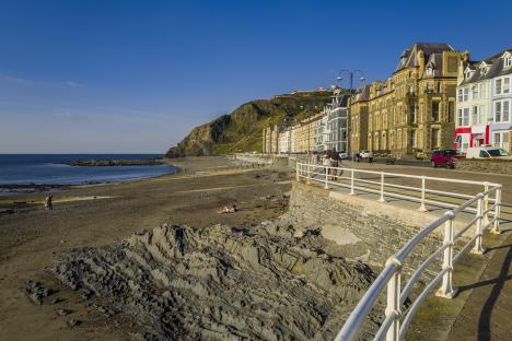 Aberystwyth seaside resort promenade with beach and buildings.