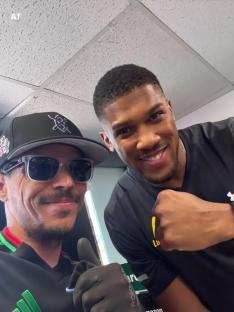 Anthony Joshua and another man posing for a selfie.