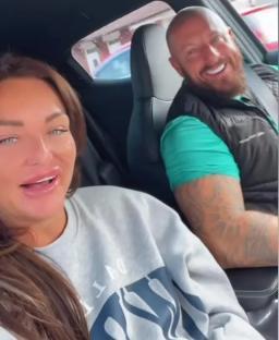 A couple in a car, smiling for the camera.