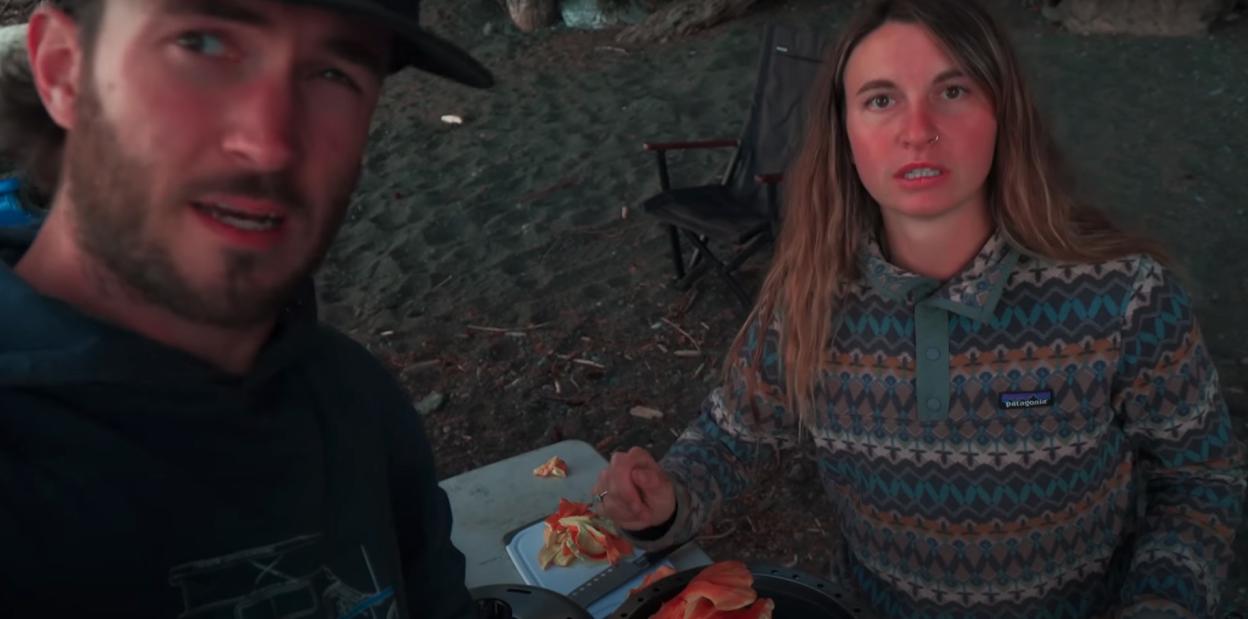 A travel influencer couple preparing food outdoors.