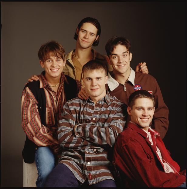Take That boy band members Mark Owen, Howard Donald, Gary Barlow, Robbie Williams, and Jason Orange posing for a portrait.