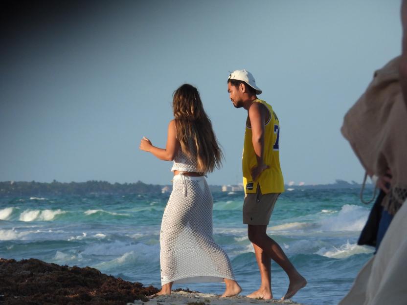 Couple walking on a beach.