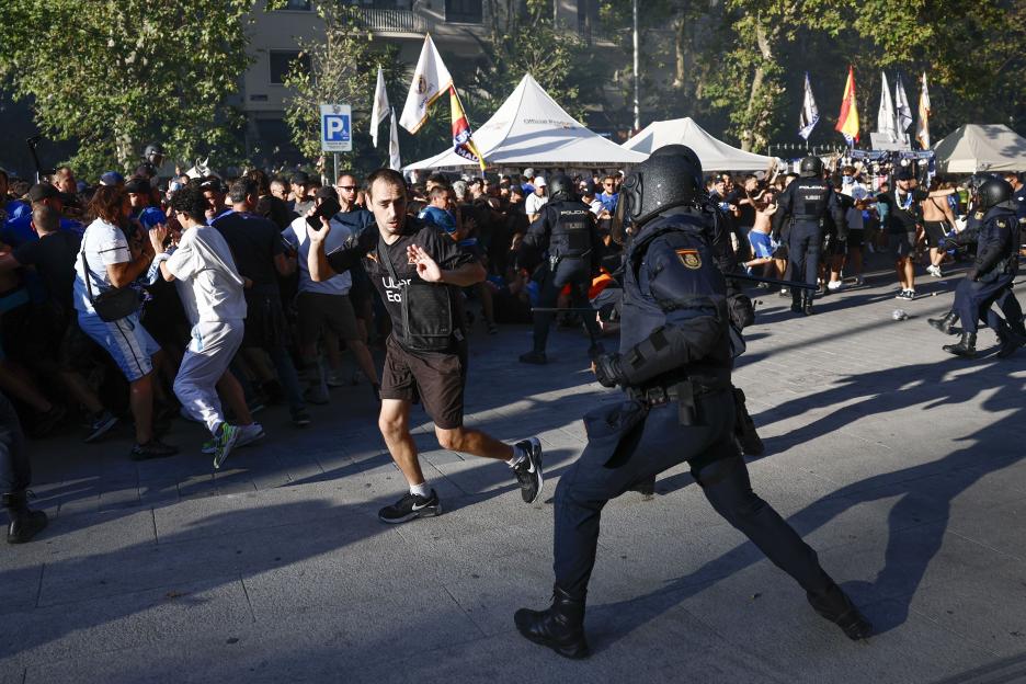Spanish national police clashing with Olympique de Marseille supporters near Santiago Bernabeu stadium.
