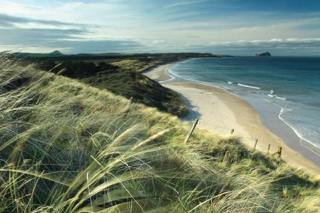 Bass Rock and North Berwick Law viewed from Ravensheigh Sands, East Lothian coastline, Scotland.