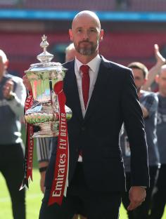 Erik ten Hag holding the Emirates FA Cup trophy.