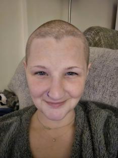 Woman with shaved head and nose ring.