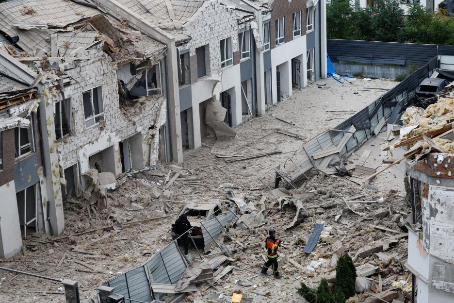 Emergency workers at a residential impact site after missile attacks.