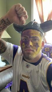 Minnesota Vikings fan with face paint and horned helmet.