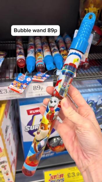 A hand holding a Paw Patrol bubble wand with a blue cap, priced at 89p.