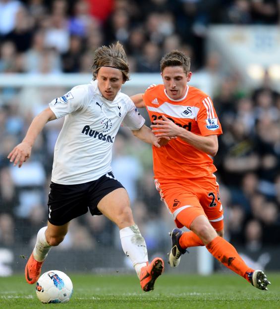 Luka Modric and Joe Allen battling for the ball during a soccer match.