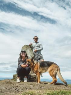 Couple and dog at a mountain summit.
