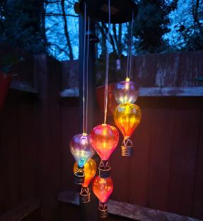 Hot air balloon-shaped lights hanging outdoors at night.