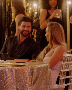 Couple seated at a table at a formal event.