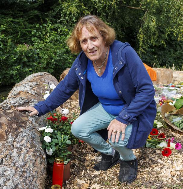 Woman laying flowers at a memorial.