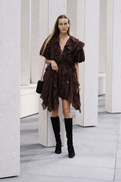 Isabel Lucas wearing a brown ruffled dress and black boots at the Aje show during Australian Fashion Week.