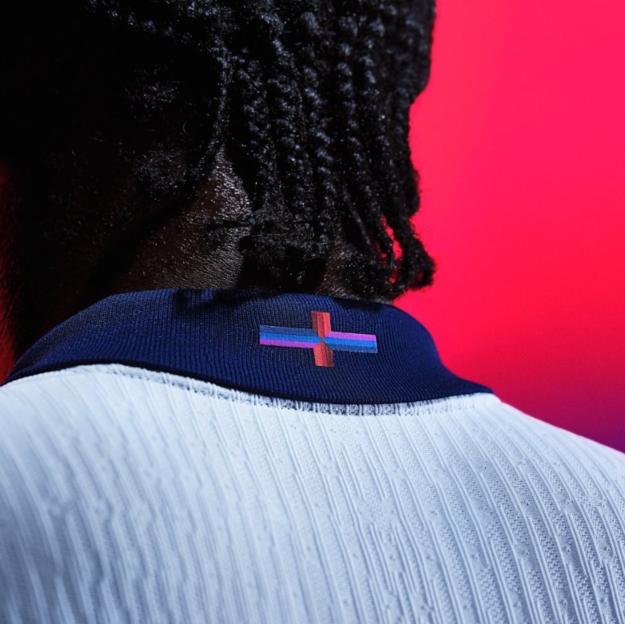 The England flag on the back collar of the new kit, with a multi-coloured cross of streaks of light and navy blue with pink instead of the traditional red cross on a white background.
