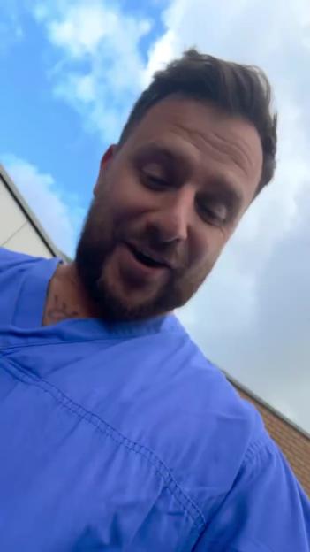 Man in blue scrubs, looks emotional.