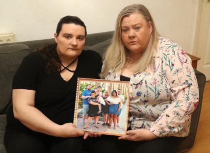 Two women holding a family photo.