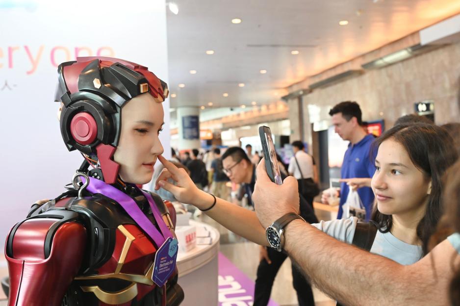 People interacting with a humanoid robot at the Hong Kong Electronics Fair.
