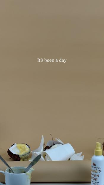 Image of coconut halves with a yellow sauce, a bottle of detangling spray, and the text "It's been a day".