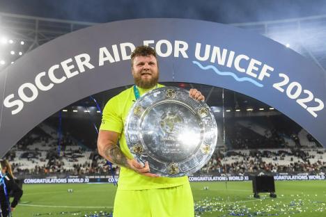 Tom Stoltman holding the Soccer Aid 2022 trophy.