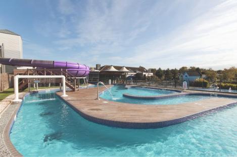 Outdoor pool complex with purple water slide.