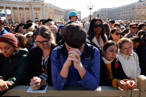 Mourners praying at a funeral mass in St. Peter's Square.