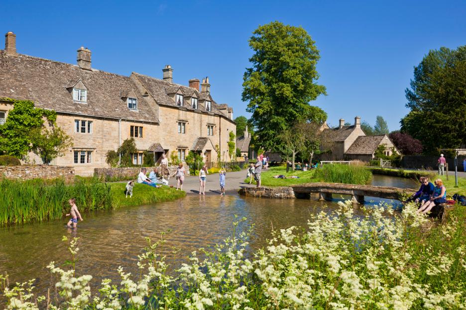 People enjoying a sunny day in Lower Slaughter, Gloucestershire, England.