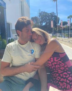 Couple embracing on a bench outdoors.
